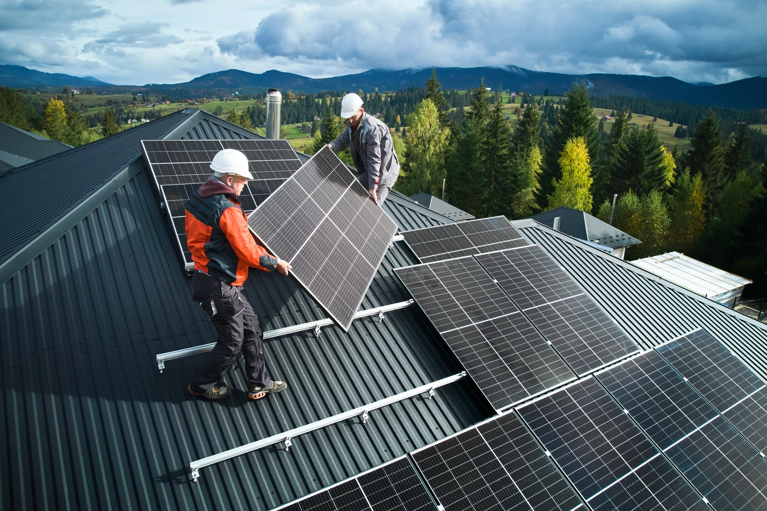 Arbeiter installieren Solaranlage auf einem Hausdach.